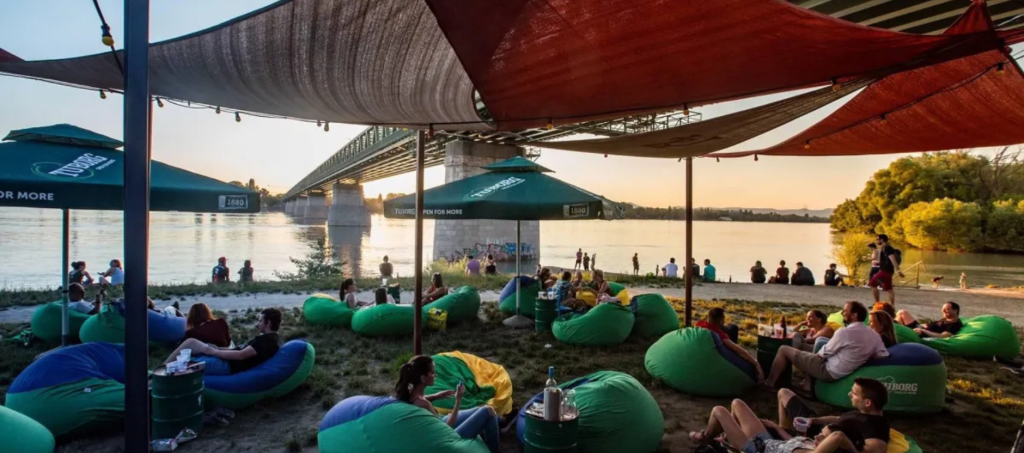 Riverside chill-out area at Népsziget with beanbags and Danube sunset views.
