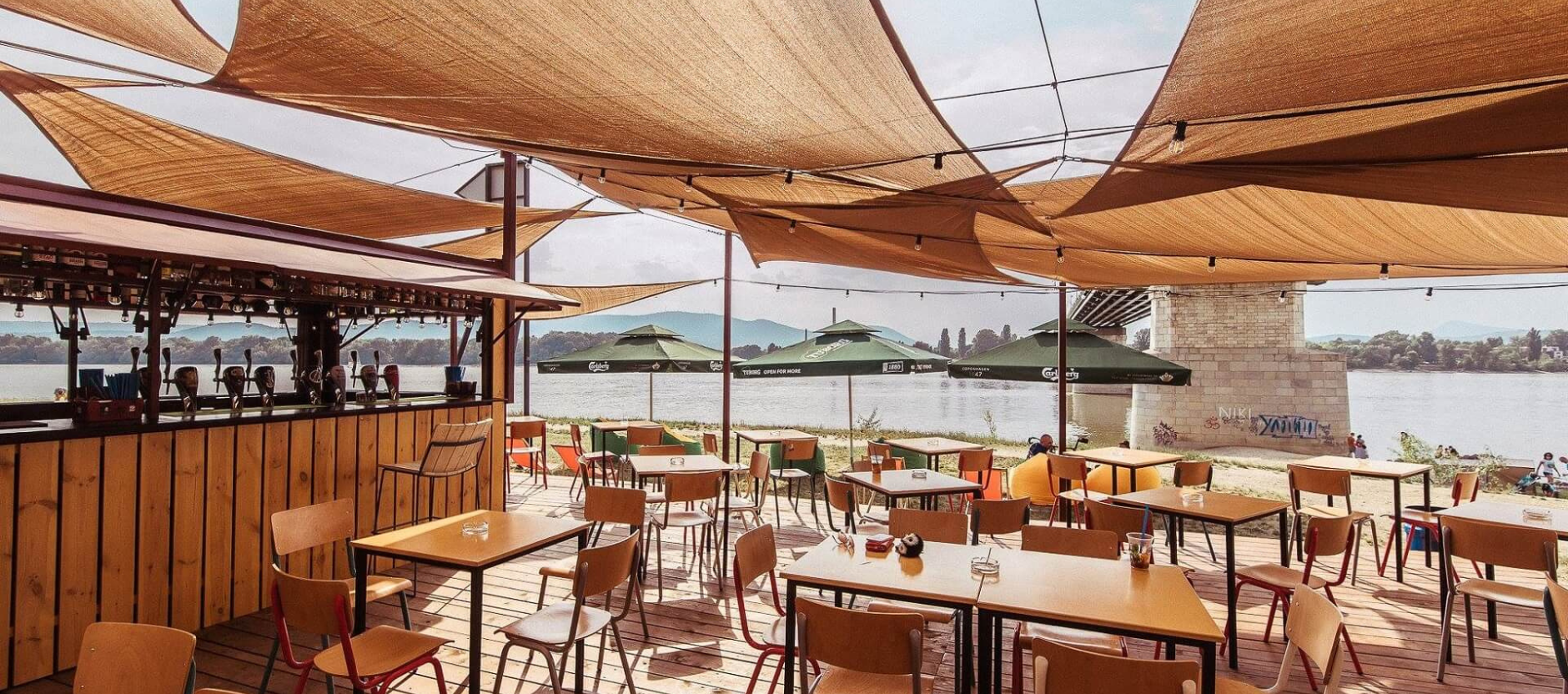 Riverside chill-out area at Népsziget with beanbags and Danube sunset views.