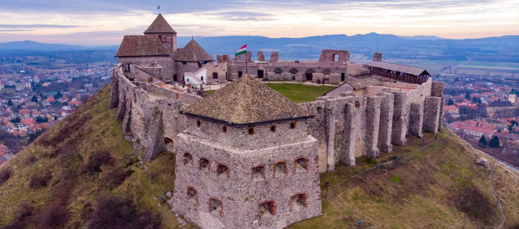 Sümeg Castle on a hilltop in Hungary, overlooking vineyards and the countryside.