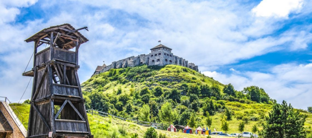 Sümeg Castle on a sunny day, medieval fortress on a hilltop in Hungary with wooden watchtower in the foreground