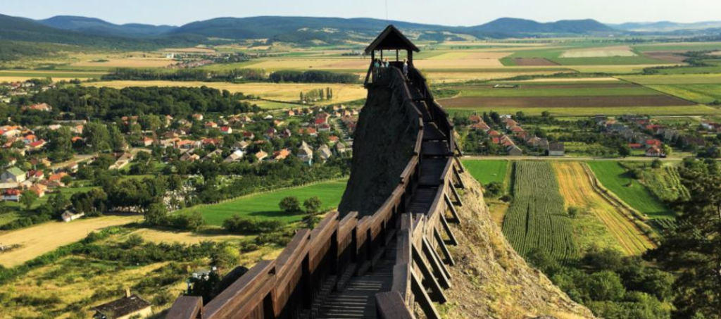 Hilltop view of Boldogkő Castle in the Zemplén Mountains with its wooden walkway and medieval-style tents below.