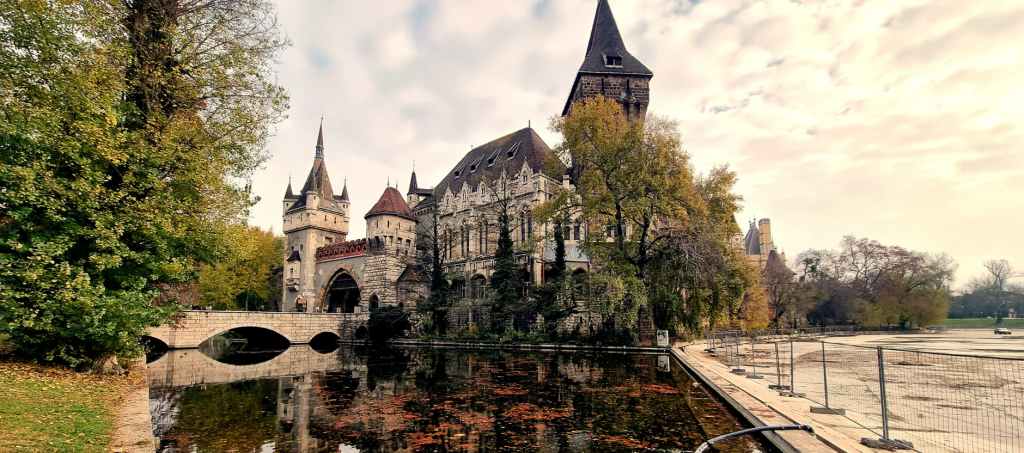 Romantic view of Vajdahunyad Castle reflected in the lake at Budapest’s City Park, surrounded by autumn trees.